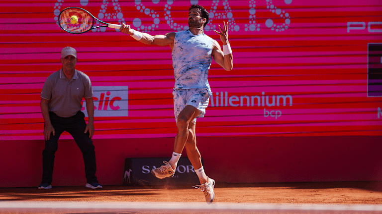 A line umpire holds the baseline behind Andrea Pellegrino at the Estoril Challenger.